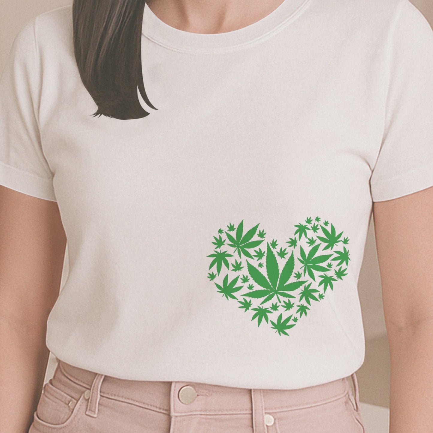 Person wearing a white t-shirt with a green heart design made of leaf shapes, standing in a room.