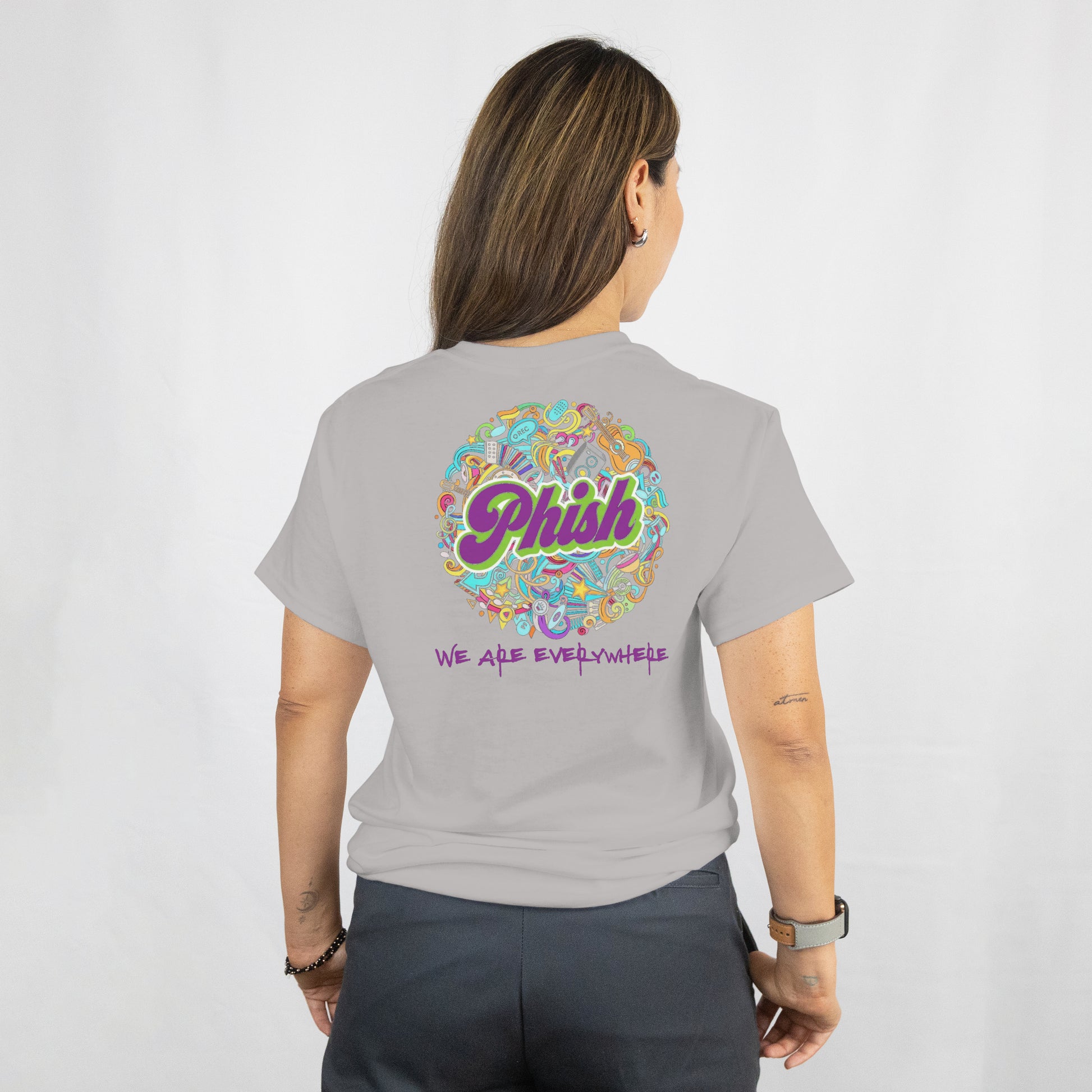 Person wearing a gray t-shirt with a colorful 'Phish' logo on the back.