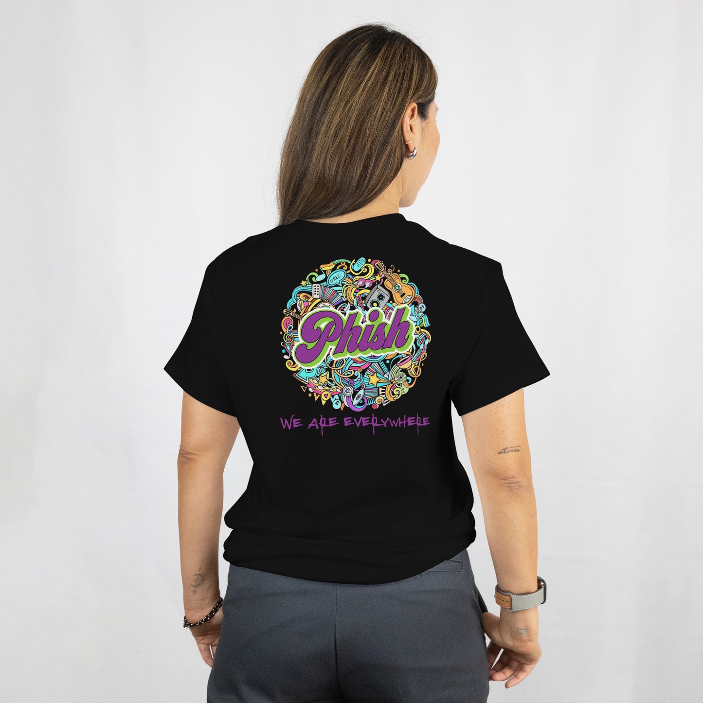 Person wearing a black t-shirt with colorful 'Phish' logo and text on the back.