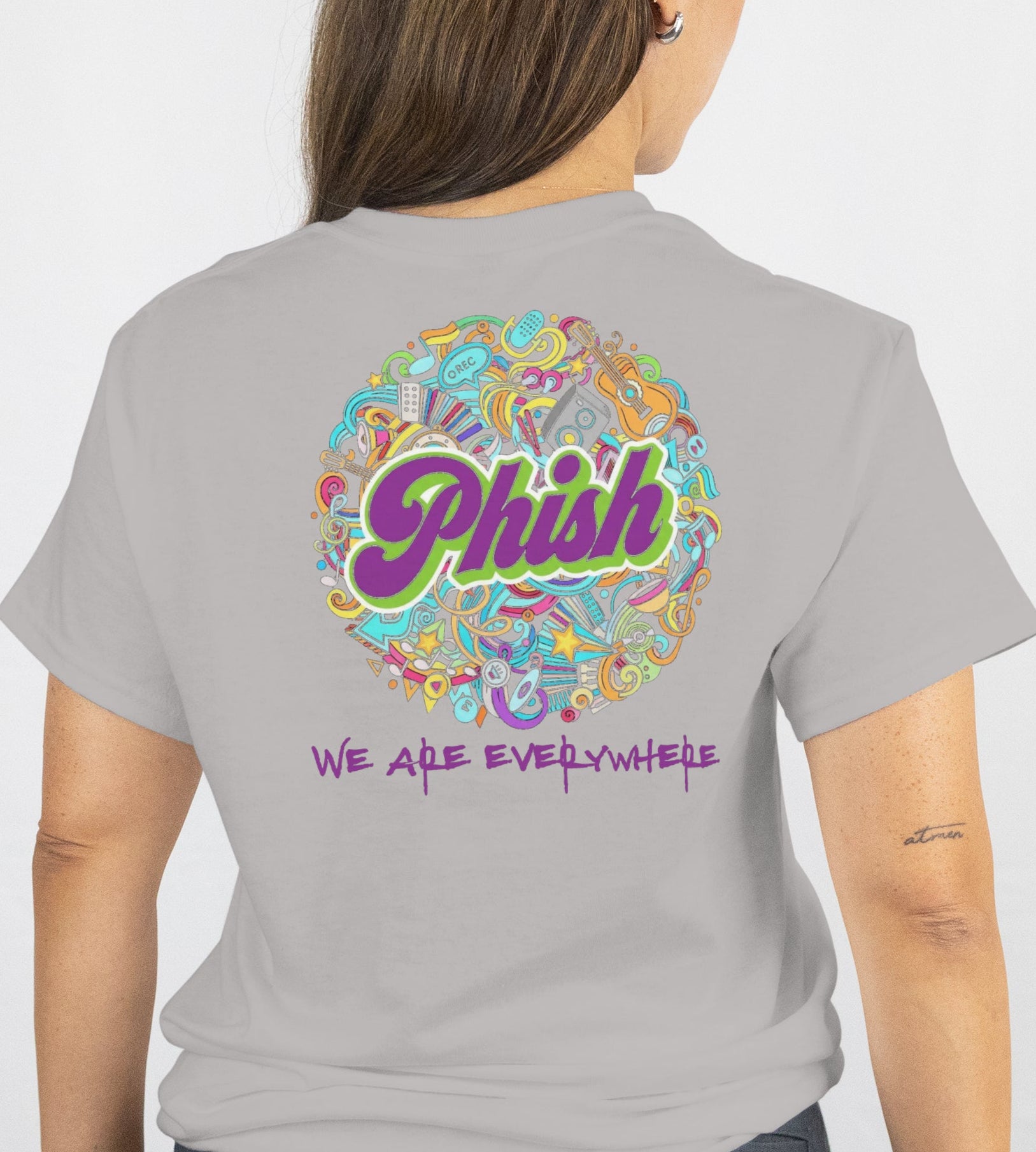 Person wearing a gray t-shirt with colorful 'Phish' logo on the back
