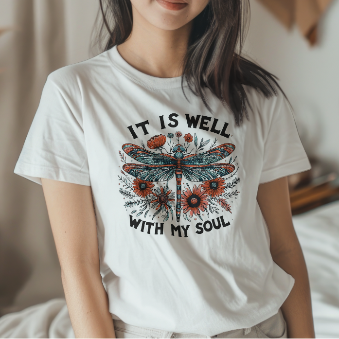 Woman wearing a white t-shirt with a dragonfly design and text in a casual setting.