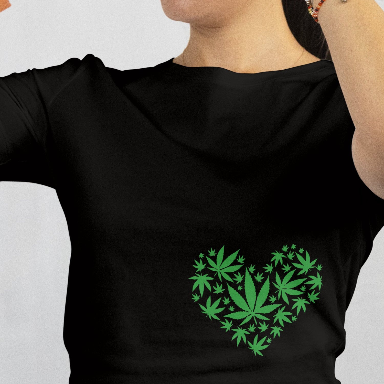 Woman wearing a black t-shirt with green leaf design and sunglasses, on a plain background