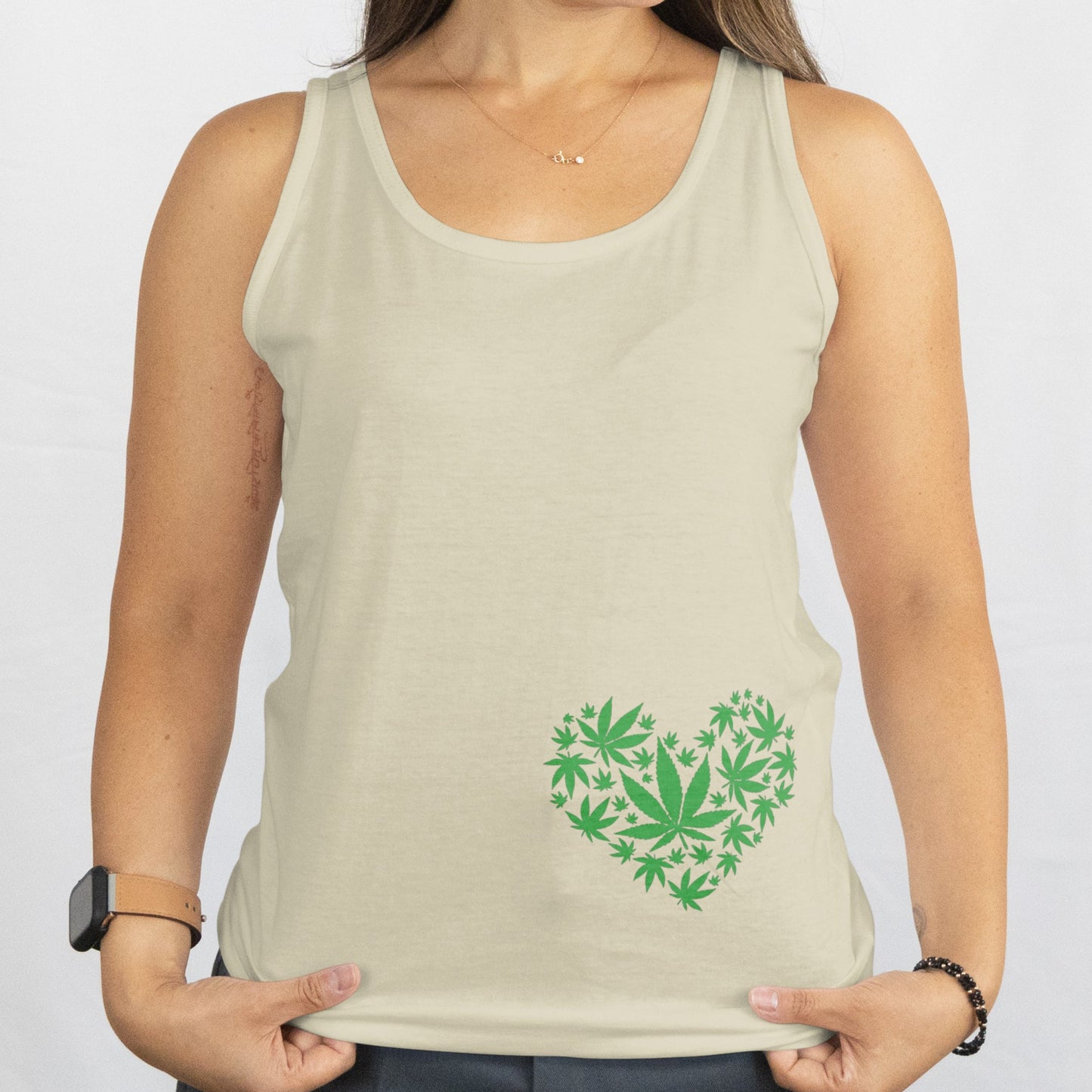 Woman wearing a beige tank top with a green heart design on a white background