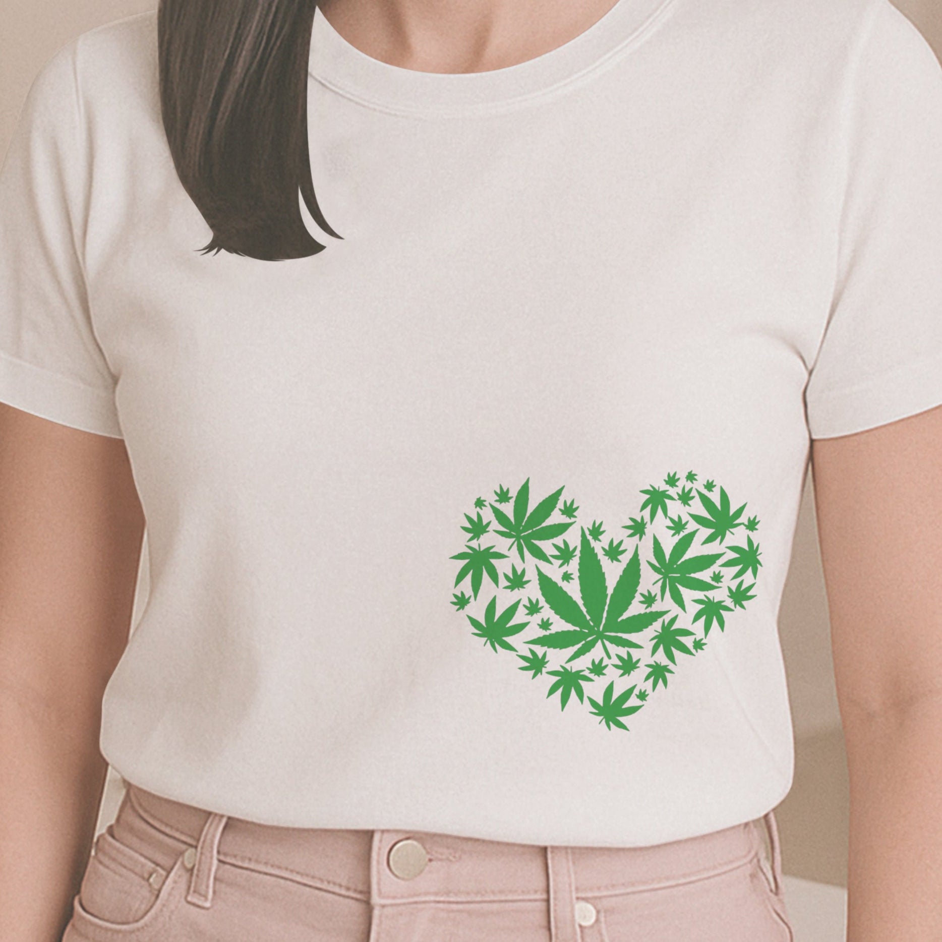 Person wearing a white t-shirt with a green heart design made of leaf shapes, standing in a room.