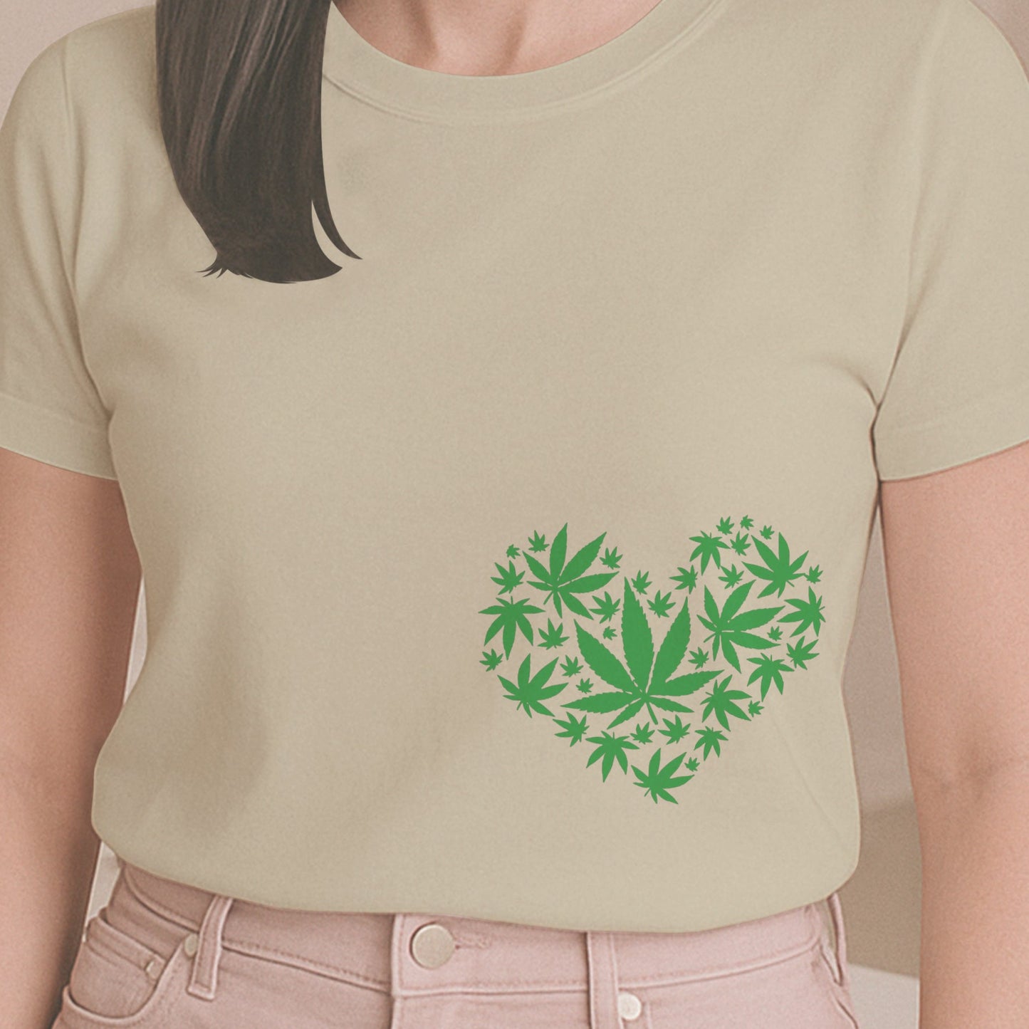 Person wearing a light green t-shirt with a heart-shaped design of green leaves indoors.