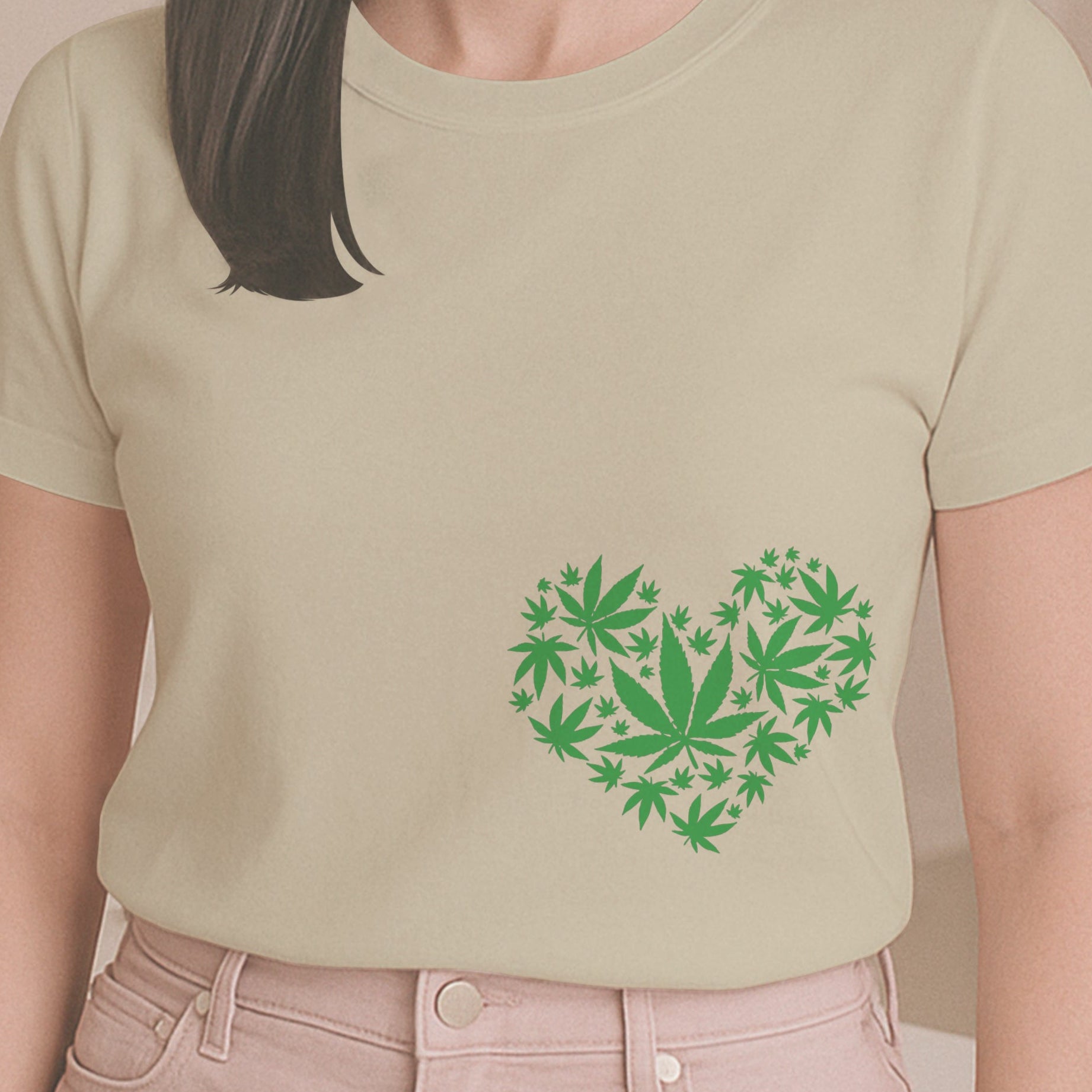 Person wearing a light green t-shirt with a heart-shaped design of green leaves indoors.