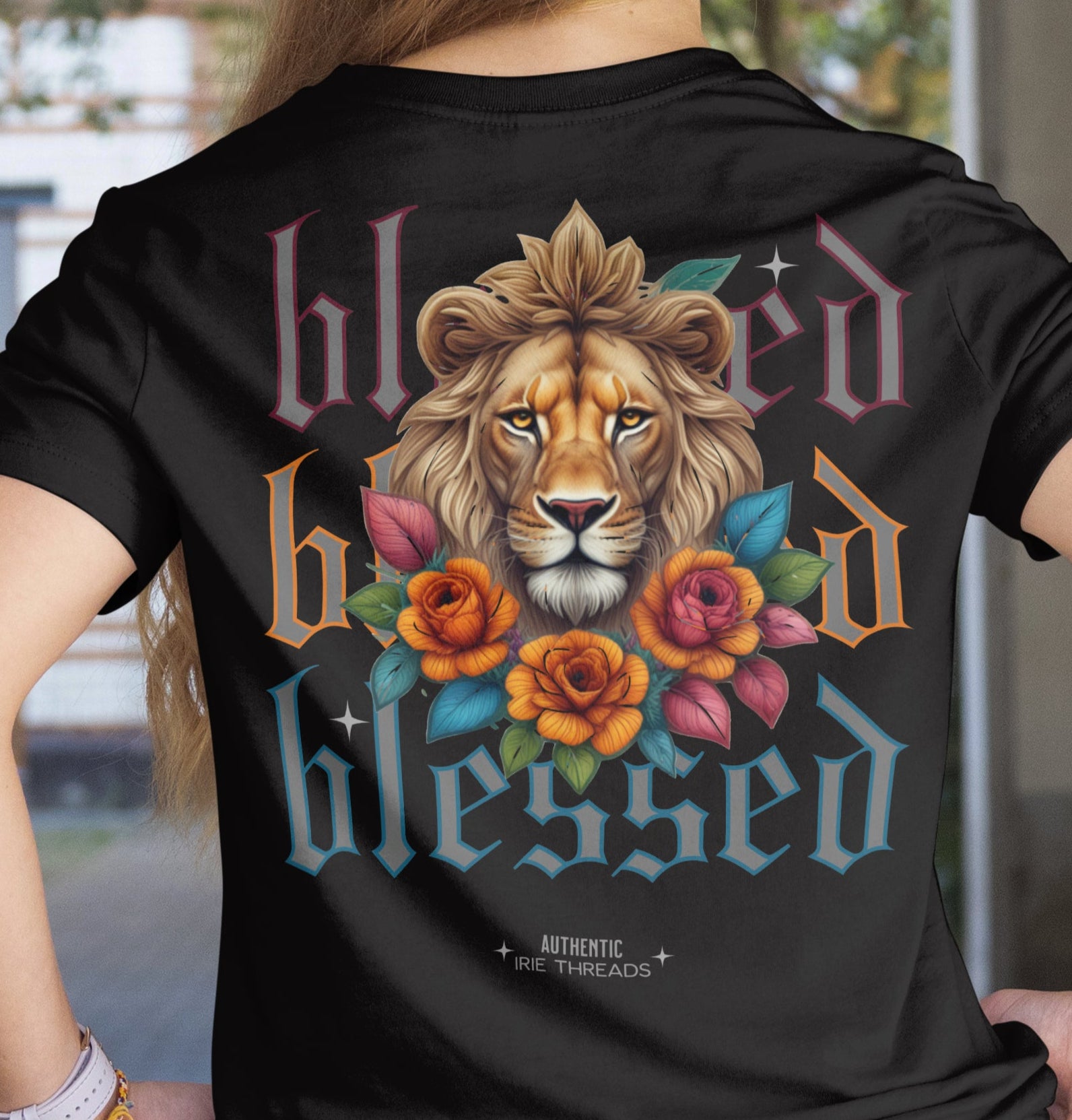 Person wearing a black t-shirt with a lion graphic and 'blessed' text.